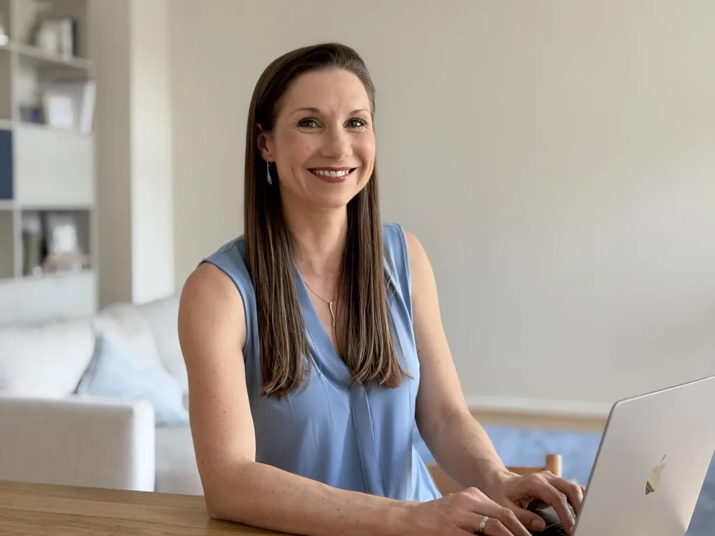 Dawn smiling at her desk with her laptop open